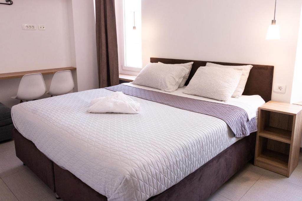 um quarto com uma cama grande e lençóis brancos em Hostel Museum em Koper