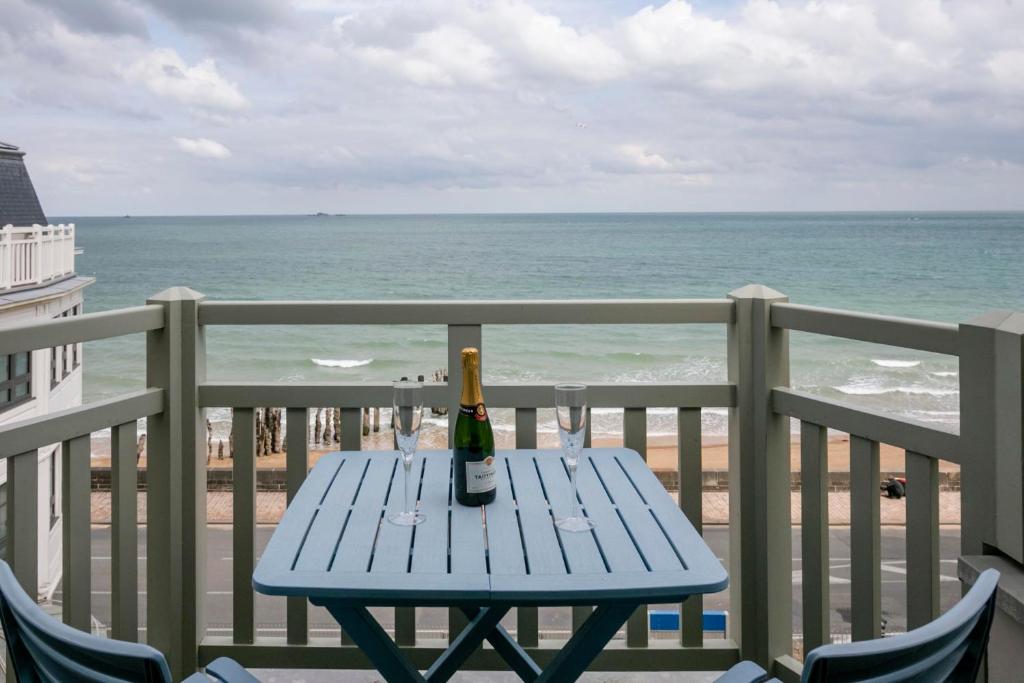 - une bouteille de vin sur une table de pique-nique sur un balcon donnant sur la plage dans l'établissement Le Grand Sillon, à Saint-Malo