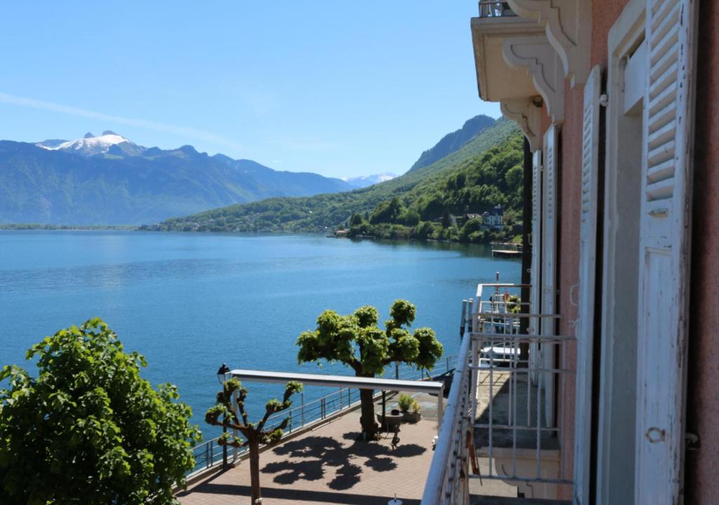 uma varanda de um edifício com vista para um lago em Hotel Le Rivage em Saint-Gingolph