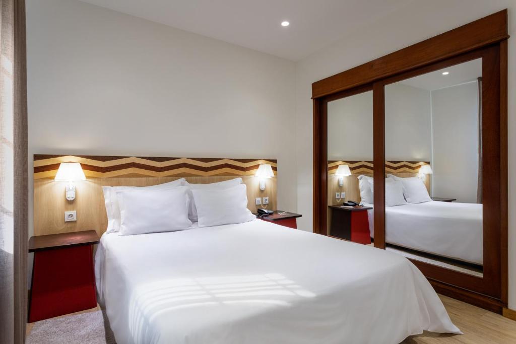 מיטה או מיטות בחדר ב-Hotel Aveiro Center