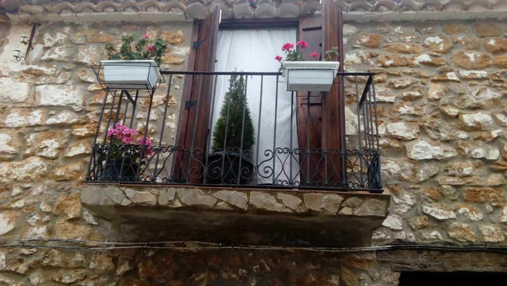 ein Fenster mit einem Balkon mit Blumen darauf in der Unterkunft Casa Leonor in Bel