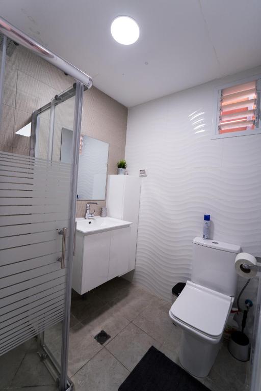 a bathroom with a toilet and a sink at Neviot in Eilat