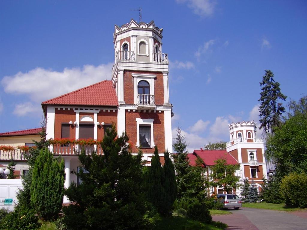 un edificio con una torre encima en Hotel Zameczek, en Radomsko