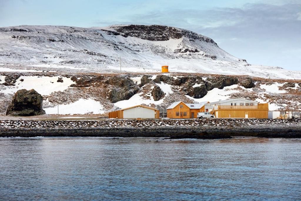 een huis aan de kant van een berg met sneeuw bij Malarhorn Guesthouse in Drangsnes