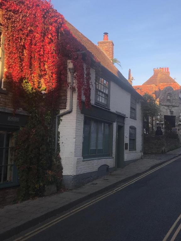 a building with red ivy on the side of a street at The Tea House in Rye