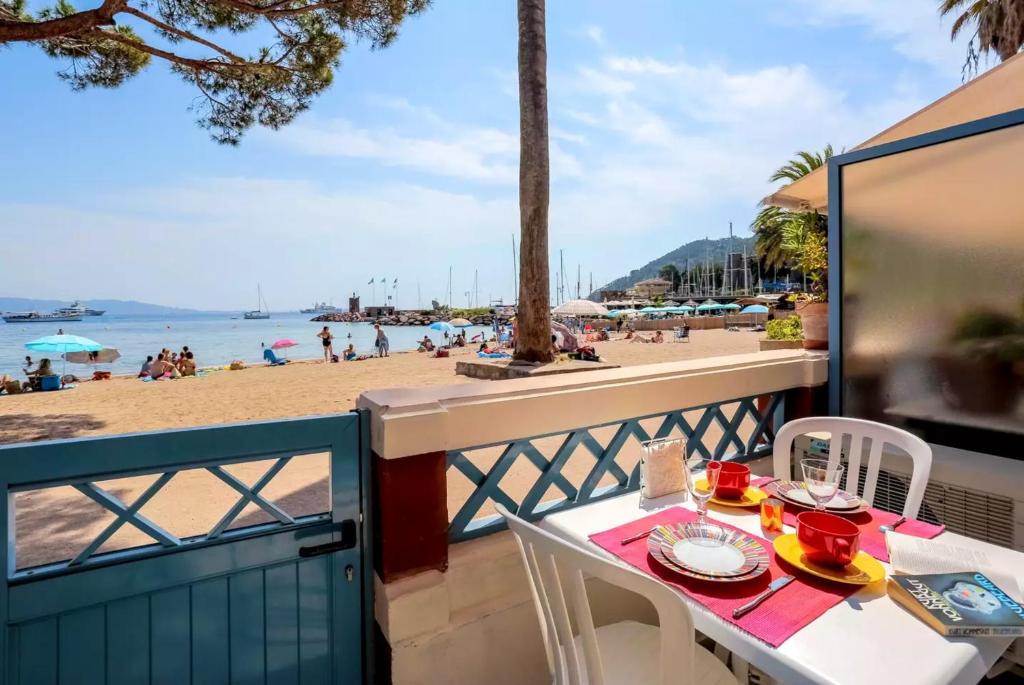 een tafel en stoelen op een balkon met uitzicht op het strand bij Appartement d'une chambre avec vue sur la mer terrasse amenagee et wifi a Theoule sur Mer in Théoule-sur-Mer