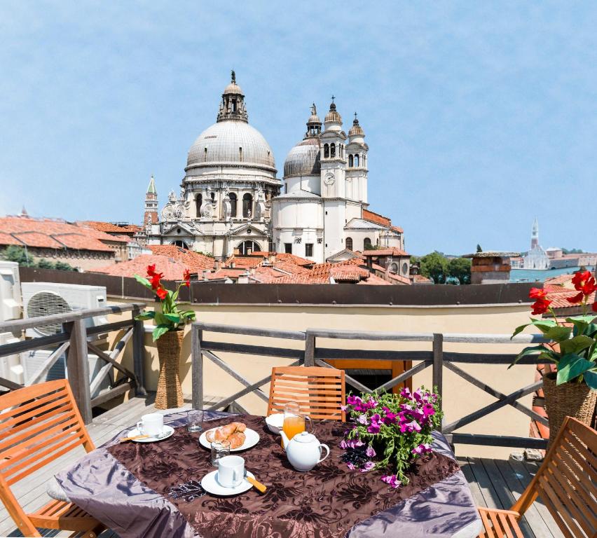a table on a balcony with a view of a building at Dorsoduro Charme Apartments in Venice