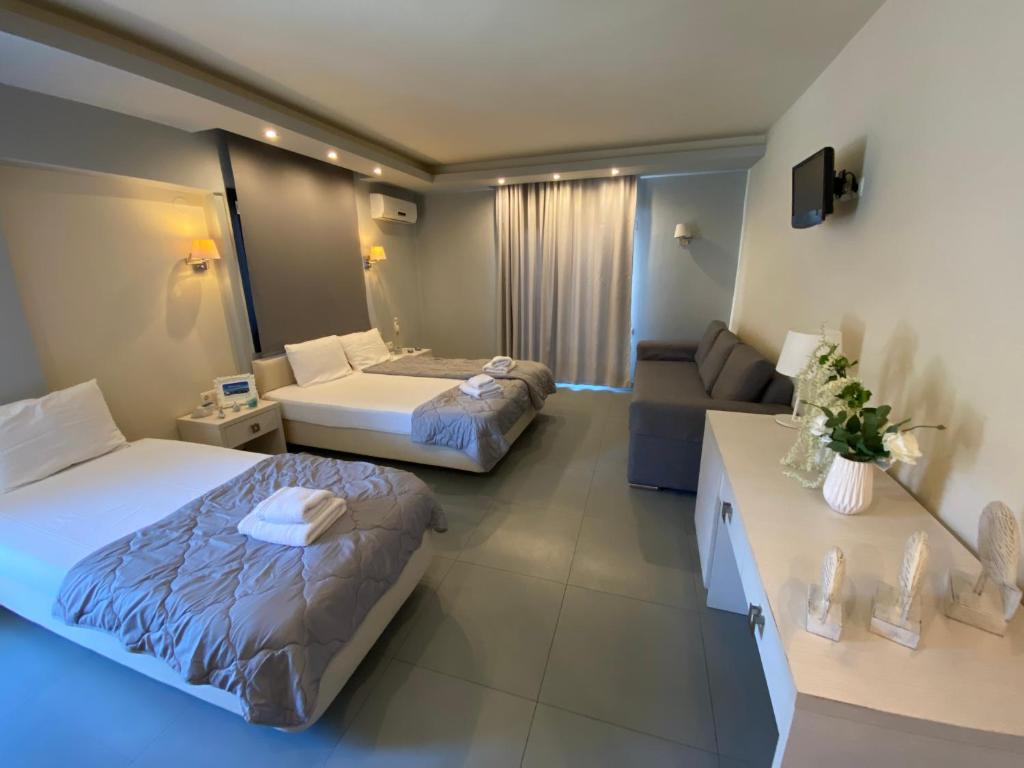 a hotel room with two beds and a couch at Blue Sea Boutique Apartments in Olympic Beach