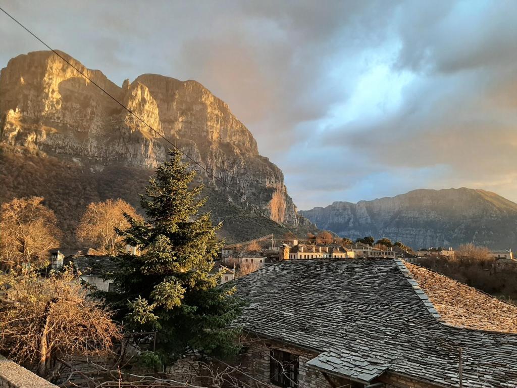 un árbol en un techo con montañas en el fondo en Radovoli, en Papigko