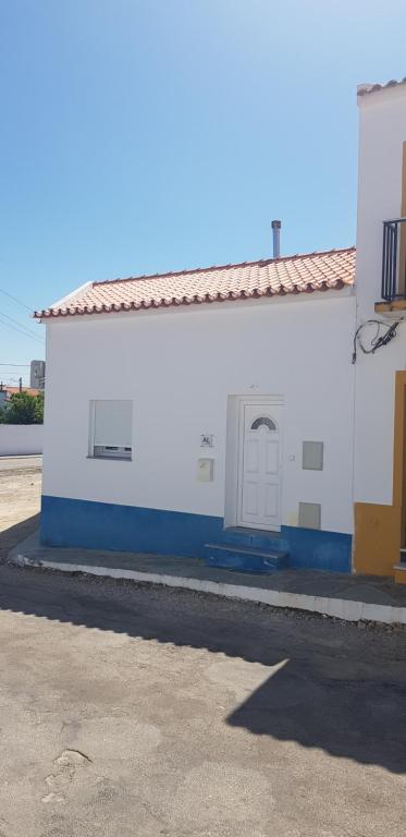 een wit en blauw gebouw met twee deuren erop bij Casa o Cantinho in Mourão