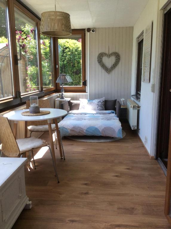 ein Schlafzimmer mit einem Bett und einem Tisch sowie einigen Fenstern in der Unterkunft Ferienwohnung mit HERZ in Laufenburg in Laufenburg