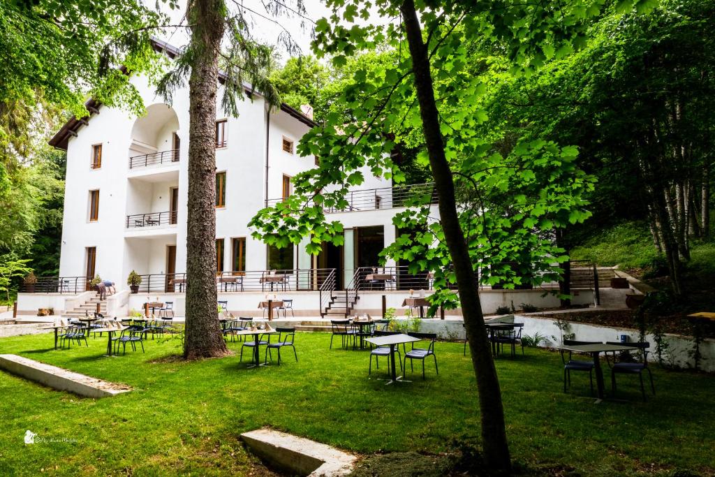 a building with tables and chairs in a park at Elda Hotel in Vico del Gargano