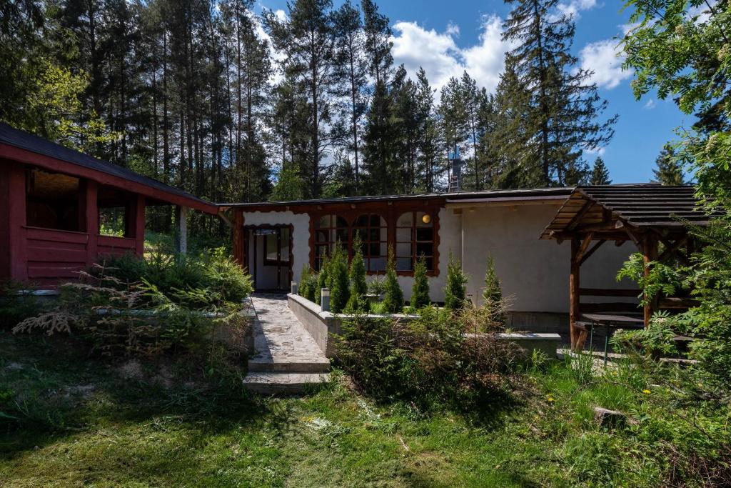 a house in the middle of a yard with trees at CHATY - woodyganovce sk in Poprad