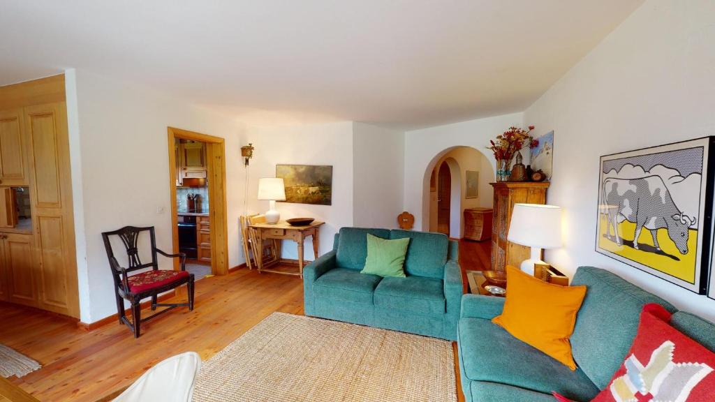 uma sala de estar com um sofá azul e almofadas amarelas em Ers em Champfer