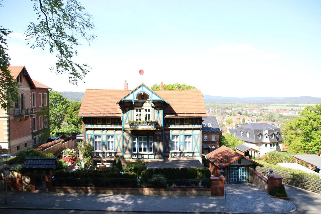 une grande maison avec un toit carrelé dans l'établissement Ferienwohnung Am Heidelberg, à Blankenburg