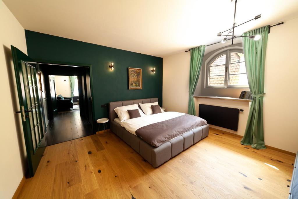 - une chambre avec un lit et un mur vert dans l'établissement Apartmány Dačický 1, à Kutná Hora