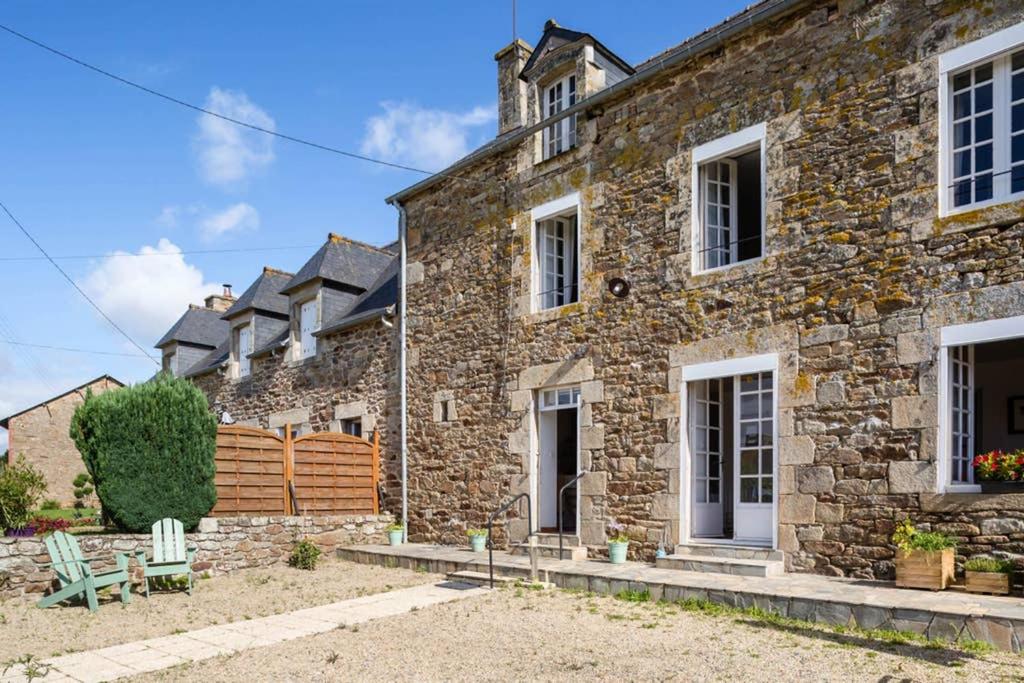 a large stone house with white doors and windows at Maison de vacances en pierre entre terre et mer in Pluduno