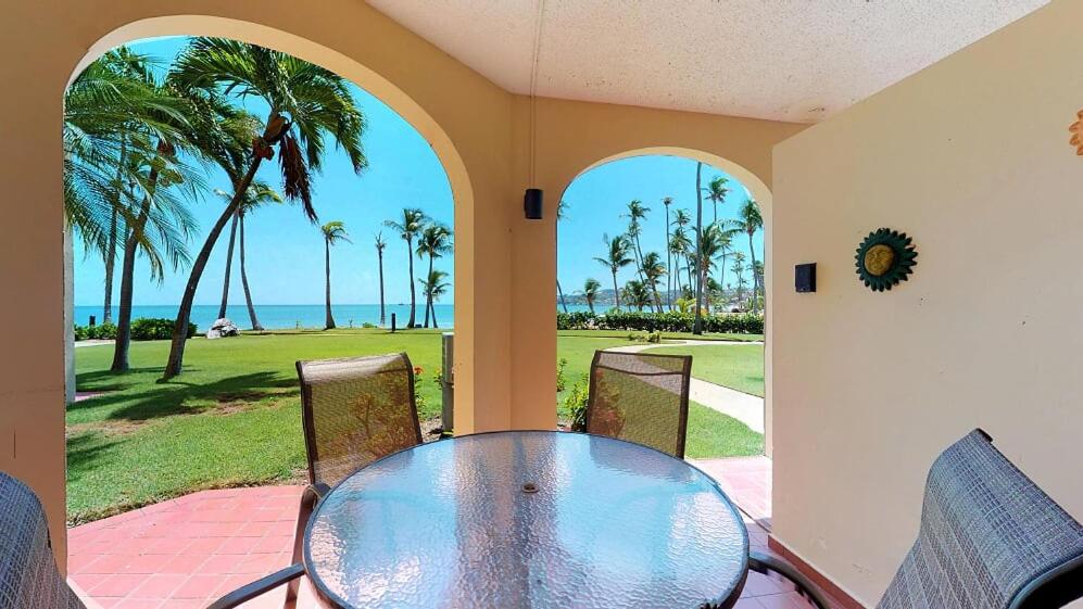 - une table et des chaises sur une terrasse avec vue sur l'océan dans l'établissement Crescent Beach 251, à Humacao