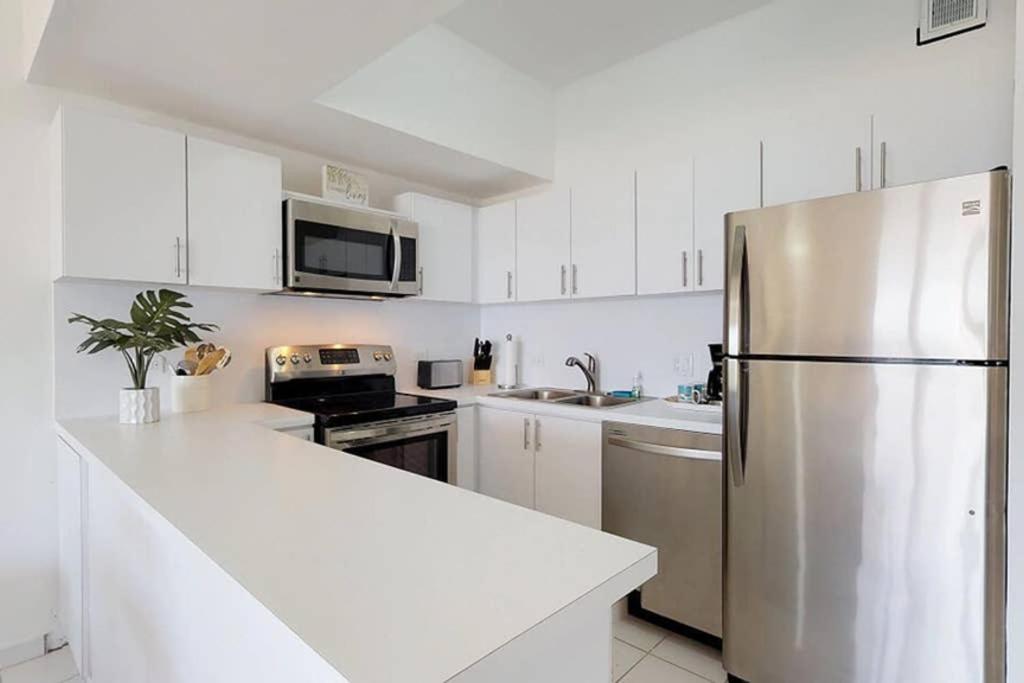 a kitchen with white cabinets and a stainless steel refrigerator at Beach Villa 233 in Humacao