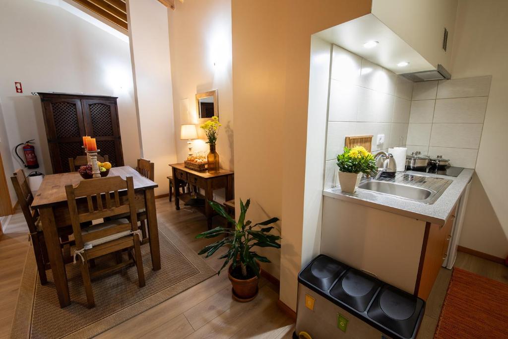 a kitchen and dining room with a sink and a table at Sete Cidades Quinta Da Queiró in Sete Cidades
