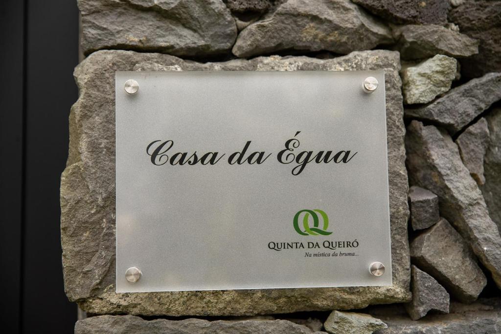 a sign for a restaurant on a stone wall at Sete Cidades Quinta Da Queiró in Sete Cidades
