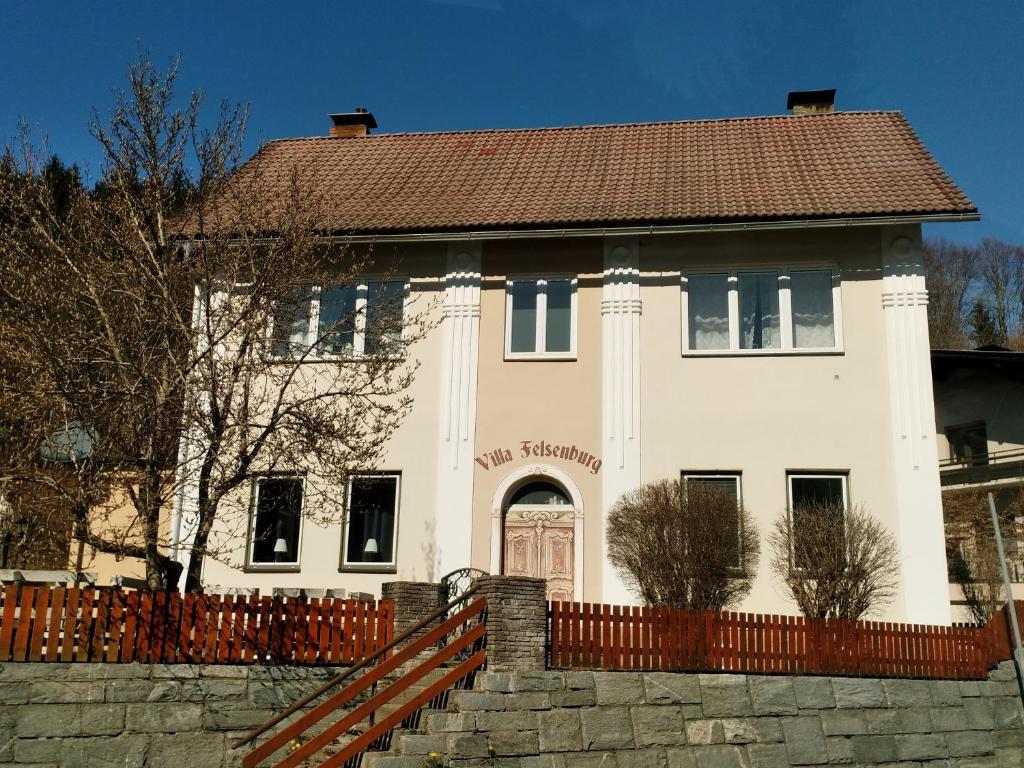 a white house with a fence in front of it at Felsenburgapartment in Hermagor