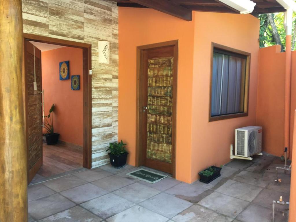 an orange house with a door and a window at Casa dos Mineiros in Arraial d'Ajuda