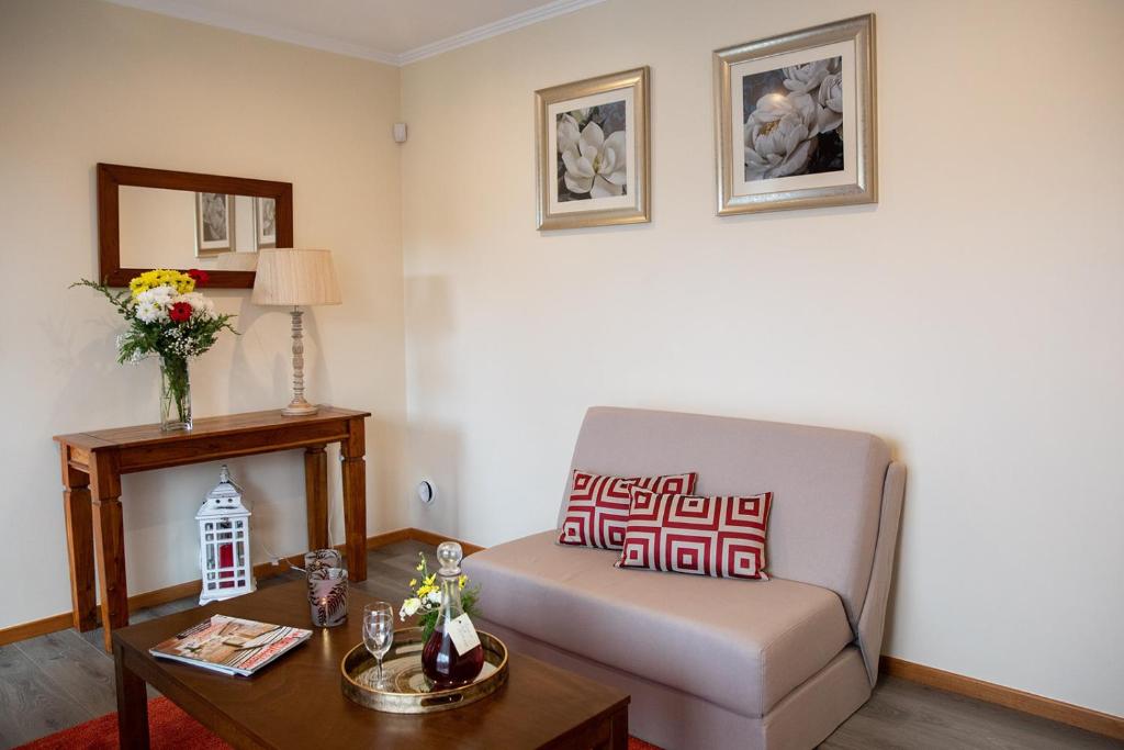 a living room with a couch and a table at Sete Cidades Quinta Da Queiró in Sete Cidades
