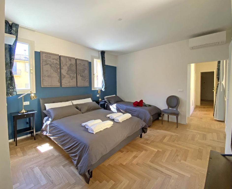 Habitación con 2 camas, paredes azules y suelo de madera. en Residenza del Duse en Bolonia