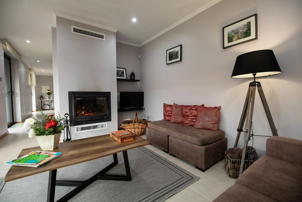 a living room with a couch and a fireplace at Sete Cidades Quinta Da Queiró in Sete Cidades