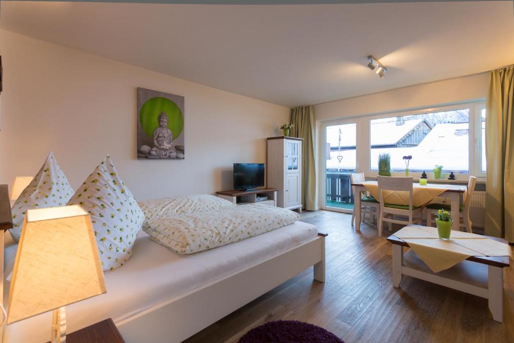 a bedroom with a bed and a living room with a table at Ferienwohnung Boland in Oberstdorf