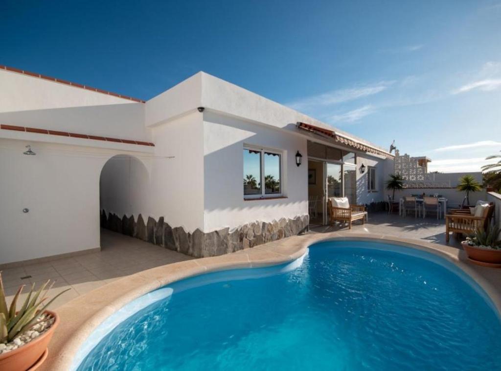 a swimming pool in front of a house at Villa Sue in Palm-mar