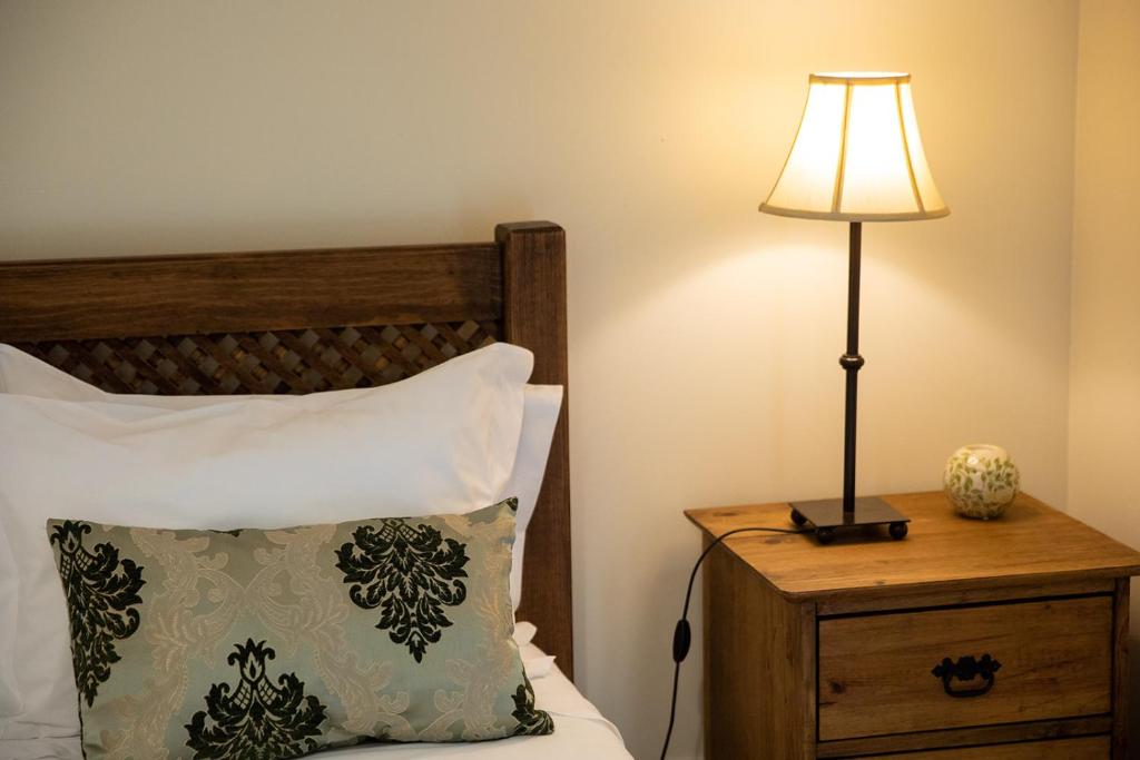a lamp on a night stand next to a bed at Sete Cidades Quinta Da Queiró in Sete Cidades