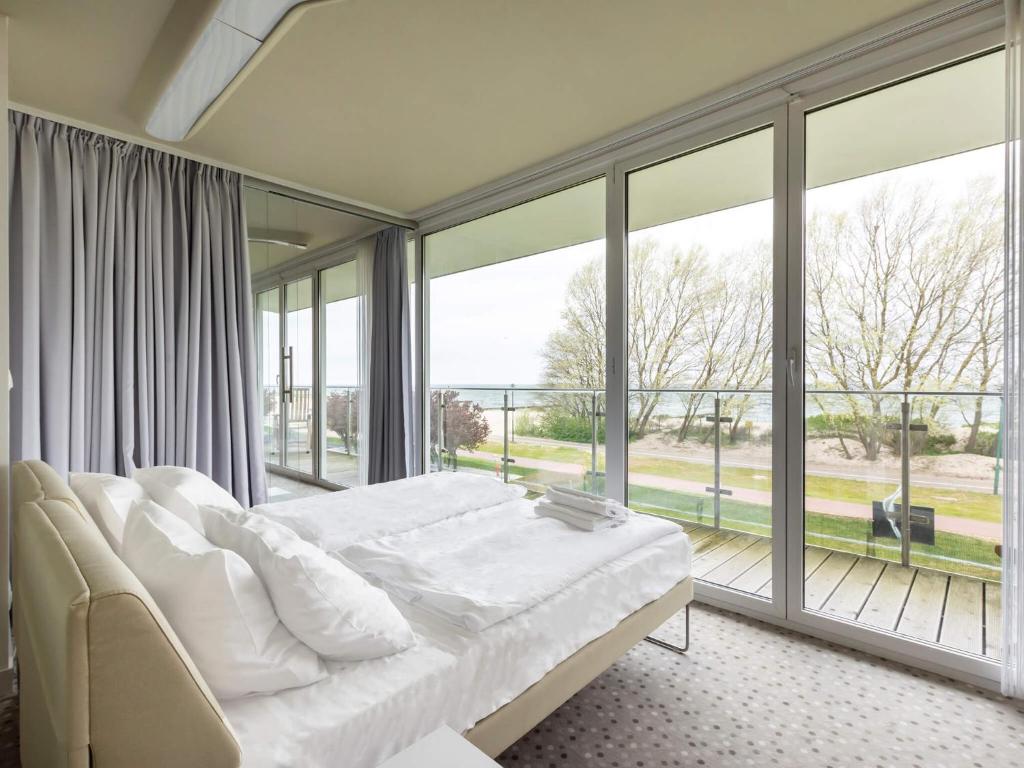 a bedroom with a bed and a large window at VacationClub – Ultra Marine Apartament 27 in Kołobrzeg