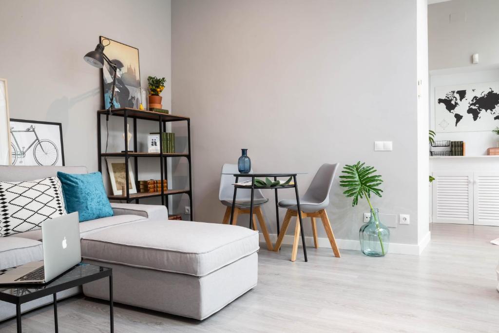 salon z kanapą i stołem z laptopem w obiekcie BeHouse Santa Cruz w Sewilli