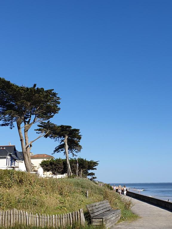 een strand met bomen en een hek en de oceaan bij Genêts d'Armor in Pornichet