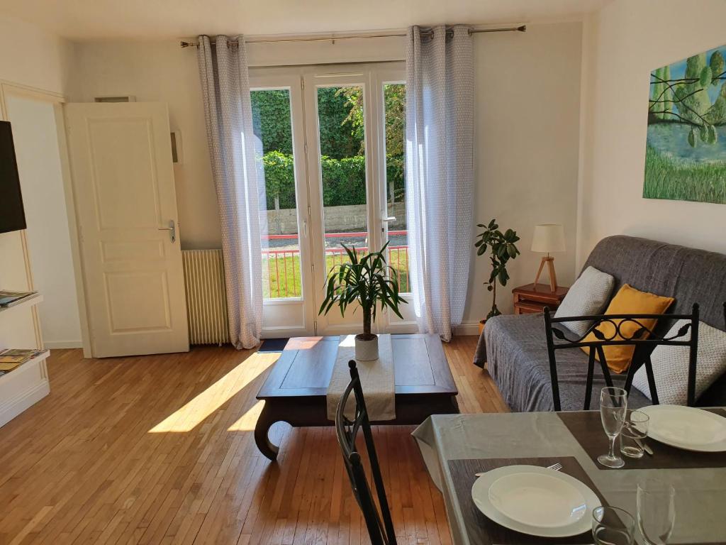 a living room with a couch and a table at Santa Maria in Saint-Ouen-de-Mimbré