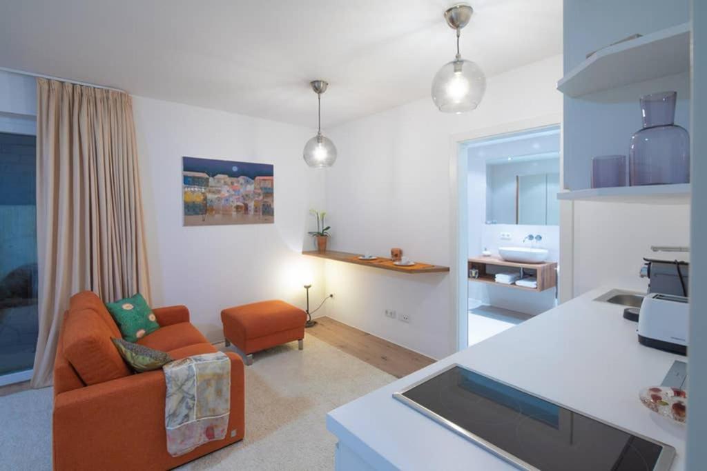 een woonkamer met een oranje stoel en een bank bij Apartment Vroni in Salzburg