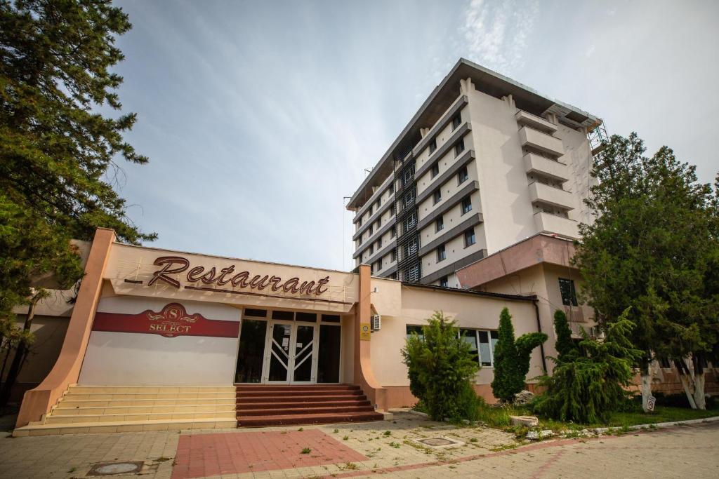 un edificio de hotel con un letrero de restaurante delante de él en Hotel Select Slobozia en Slobozia