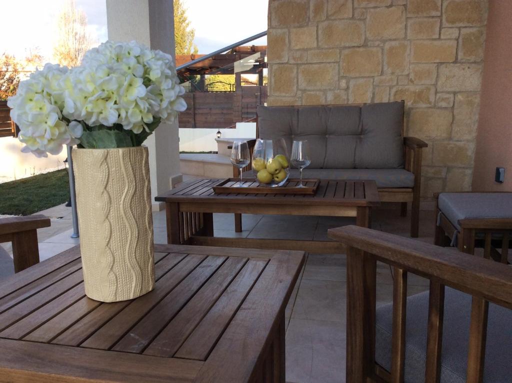 a vase of white flowers on a wooden table at Dream House Latchi Villa in Polis Chrysochous