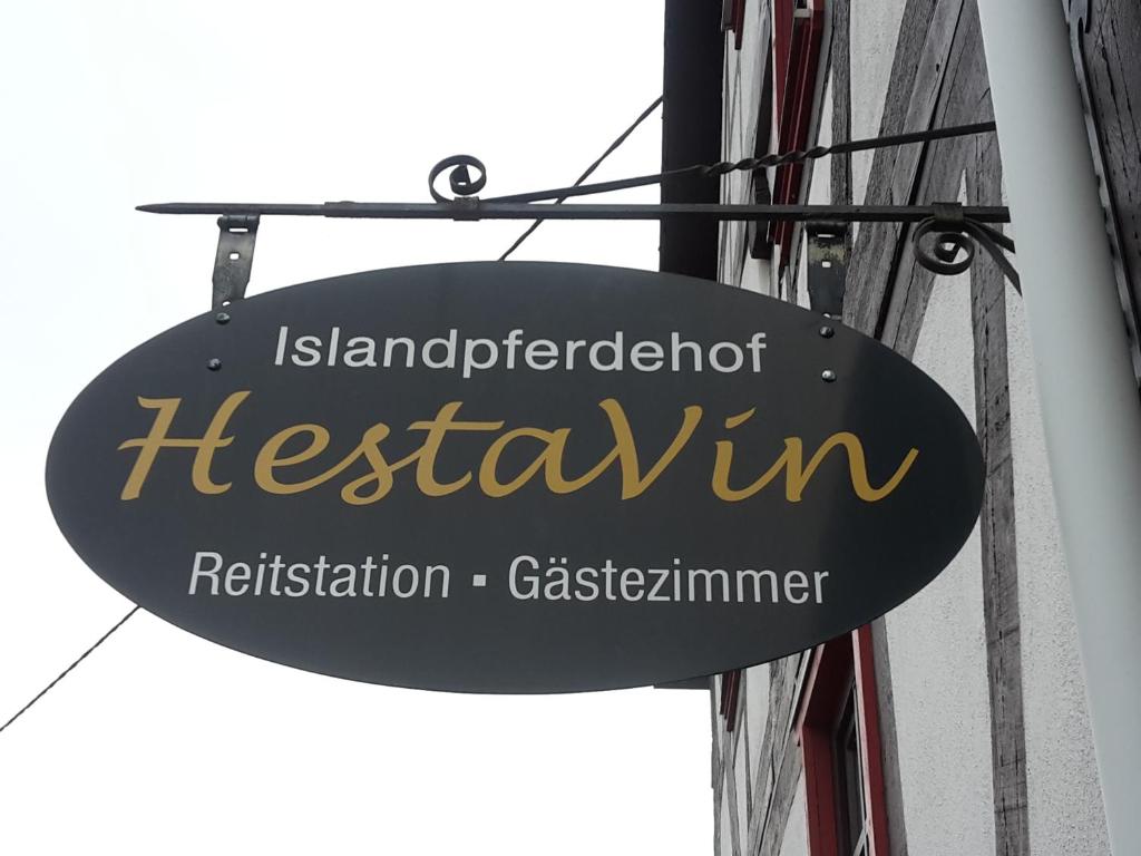 una señal para un restaurante al lado de un edificio en Hestavin Bed & Breakfast, en Grünberg