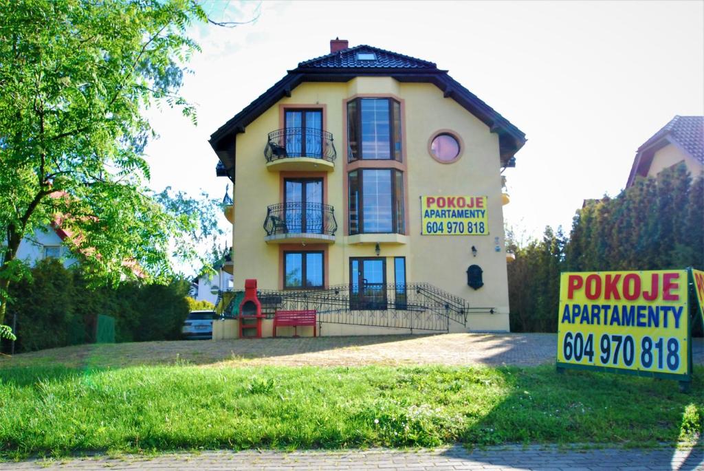 uma casa amarela com um sinal em frente em Pokoje z widokiem na morze 2 em Jastarnia