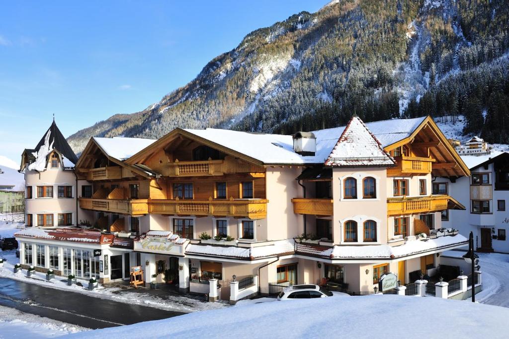 a hotel in the mountains with snow on the ground at Hotel Garni Castel B&B in Ischgl