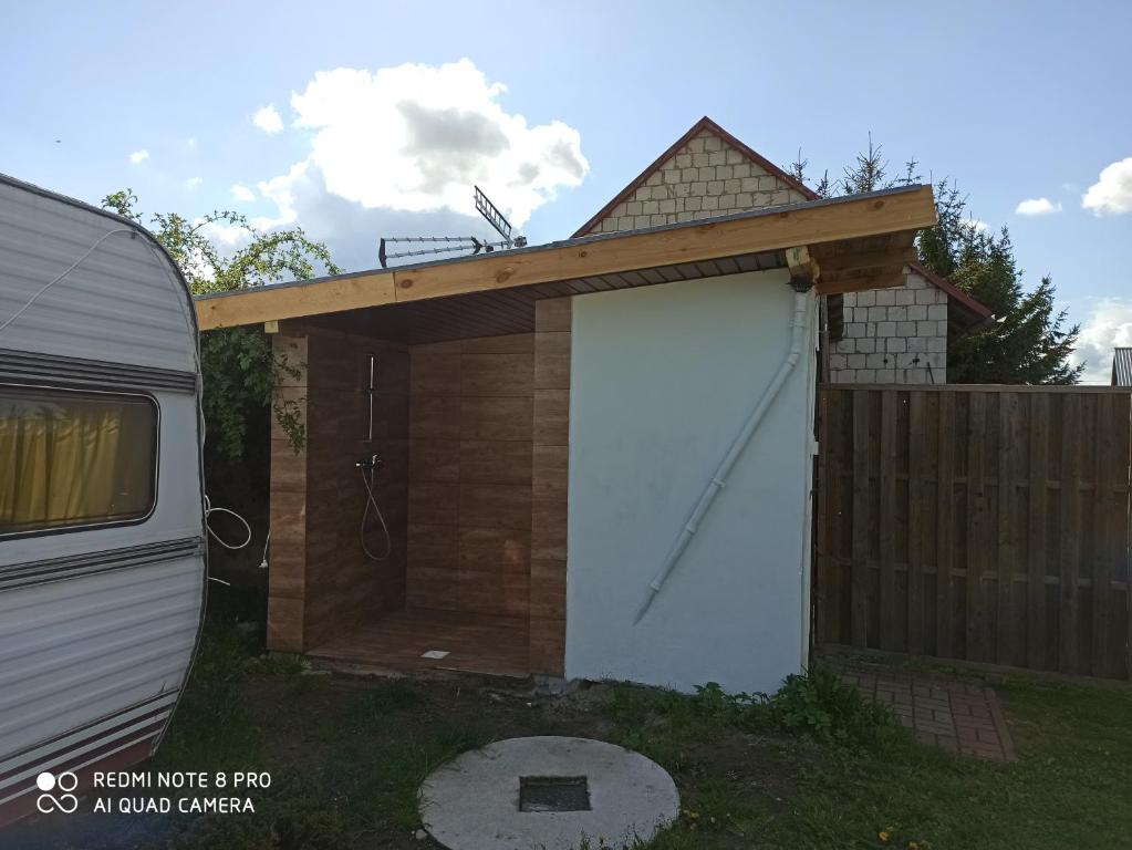a garage with a wooden door next to a fence at Camping U Mani in Wiżajny