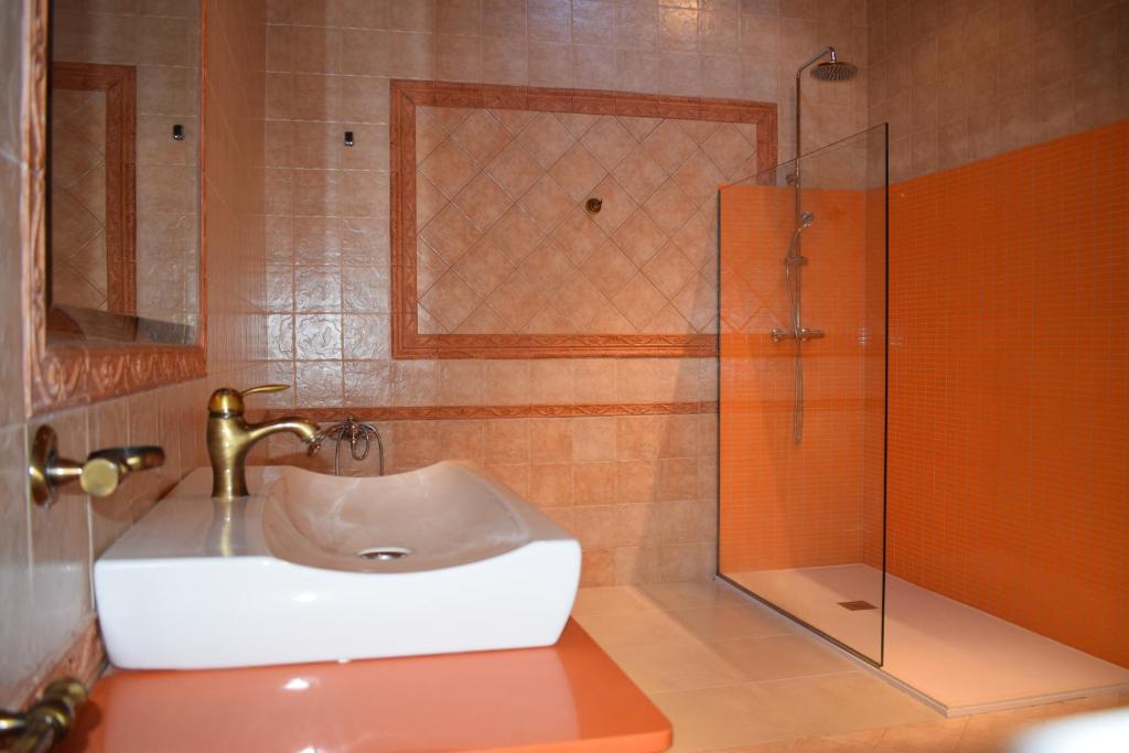 y baño con lavabo y ducha acristalada. en Apartamentos VIDA Corcubión, en Corcubión