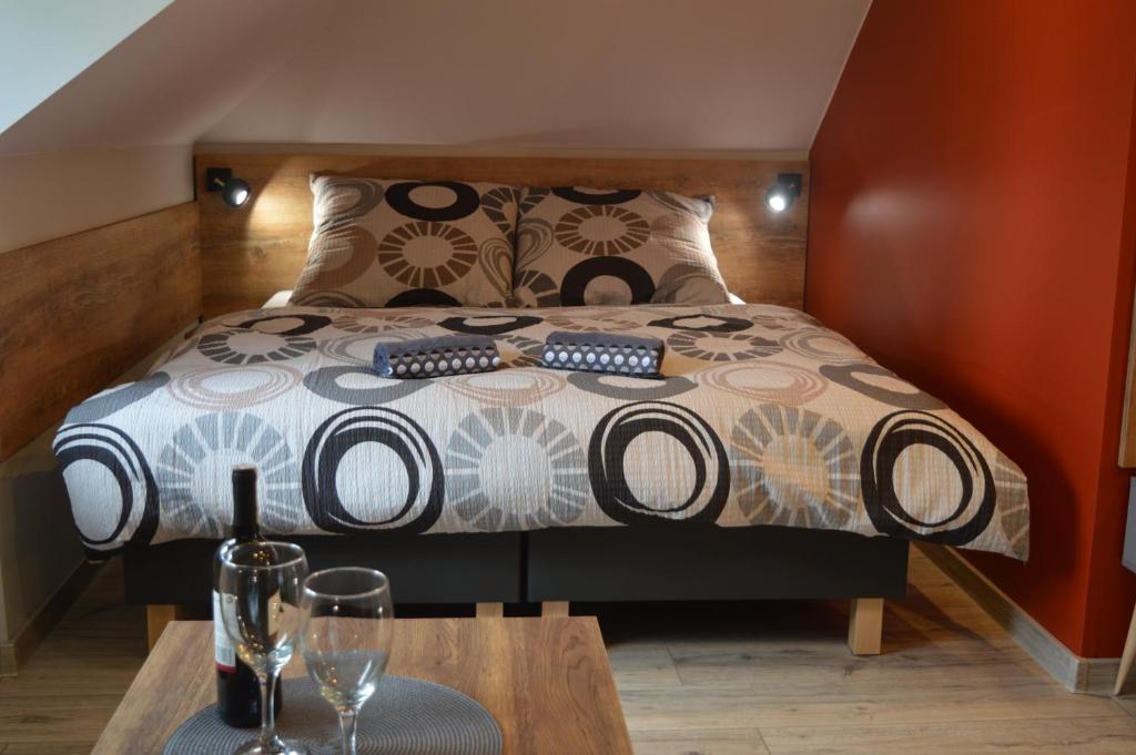 a bedroom with a bed with a table and glasses at Zacisze in Rozalin