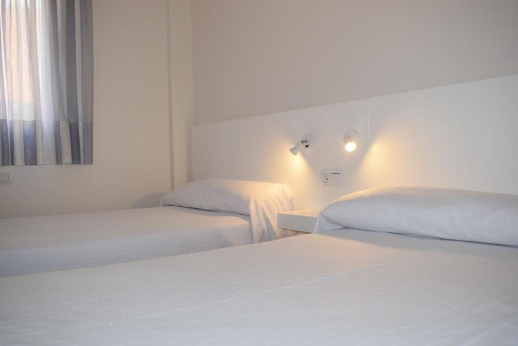 Cama o camas de una habitación en Apartamentos VIDA Corcubión