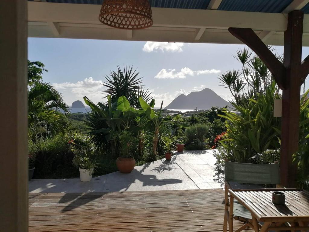 a patio with a table and a view of a mountain at Ti coin de paradis Ylang Ylang in Le Diamant