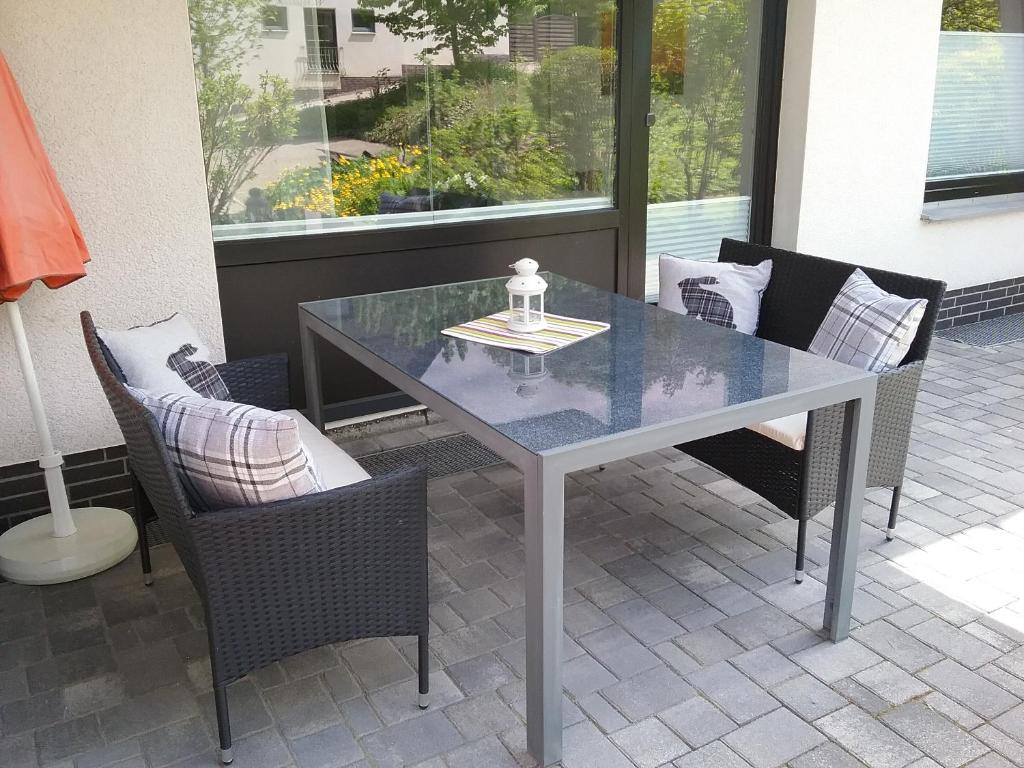 una mesa de cristal y sillas en un patio en Ferienwohnung Auszeit Parkresidenz, en Hahnenklee-Bockswiese