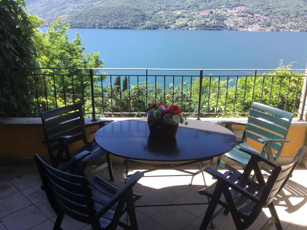 a table with a vase of flowers on a balcony at Casa Elisabetta in Dervio